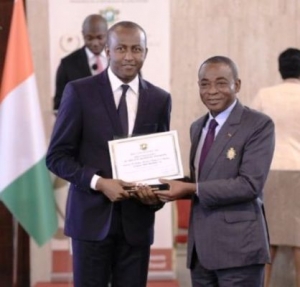Le Pdg d&#039; OPes Holding Siriki Sangaré , recevant son prix d&#039;excellence 2016 du meilleur promoteur immobilier , des mains du Président du Ces , Charles Diby Koffi au nom du président de la République , Alassane Ouattara
